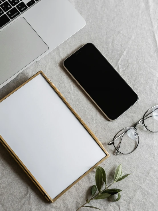 an open laptop computer sitting on top of a bed next to a pair of glasses, by Adam Rex, iphone wallpaper, light grey backdrop, gold framed, no - text no - logo