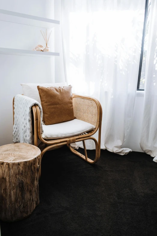 a chair sitting in a living room next to a window, unsplash, manuka, natural materials, small bedroom, plush furnishings