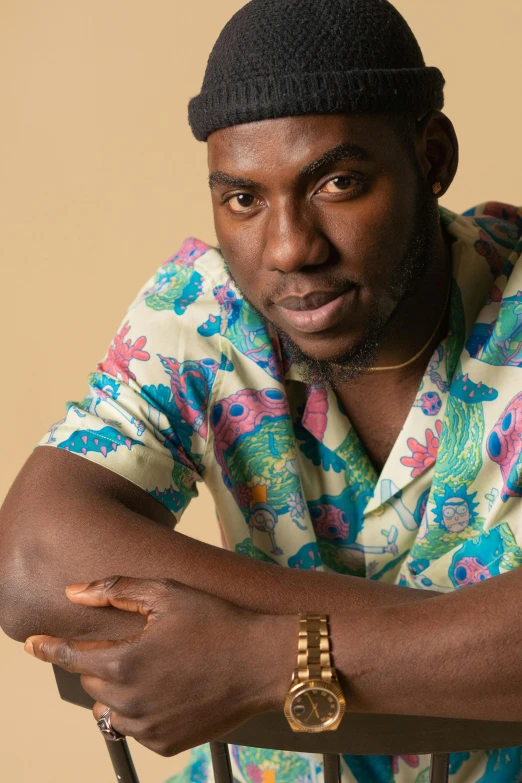 a man sitting on a chair holding a cane, an album cover, by Jessie Alexandra Dick, trending on pexels, patterned clothing, ( ( dark skin ) ), a handsome, pastel'