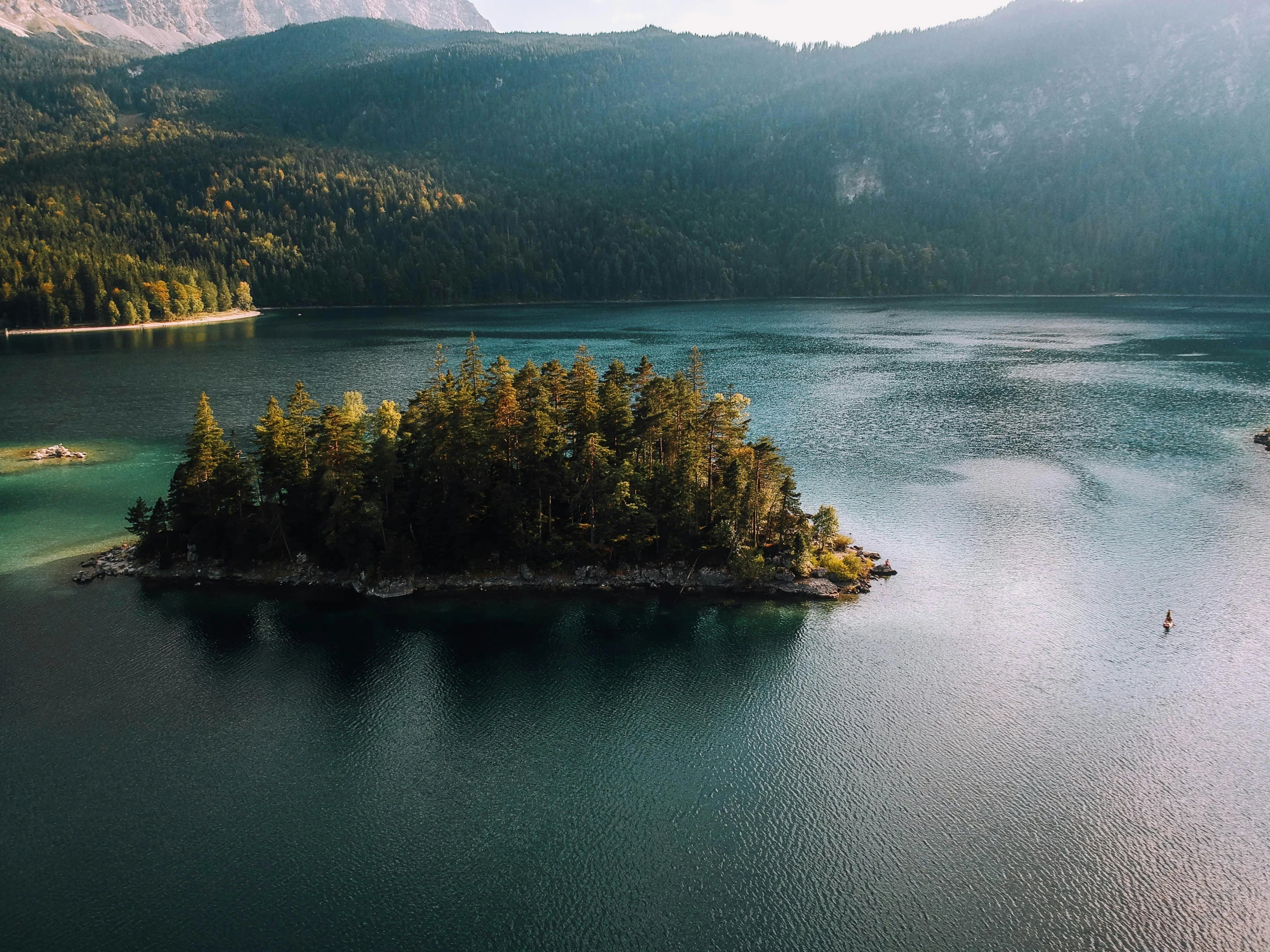a small island in the middle of a large body of water, by Sebastian Spreng, pexels contest winner, pine forests, green water, cinematic morning light, hd footage