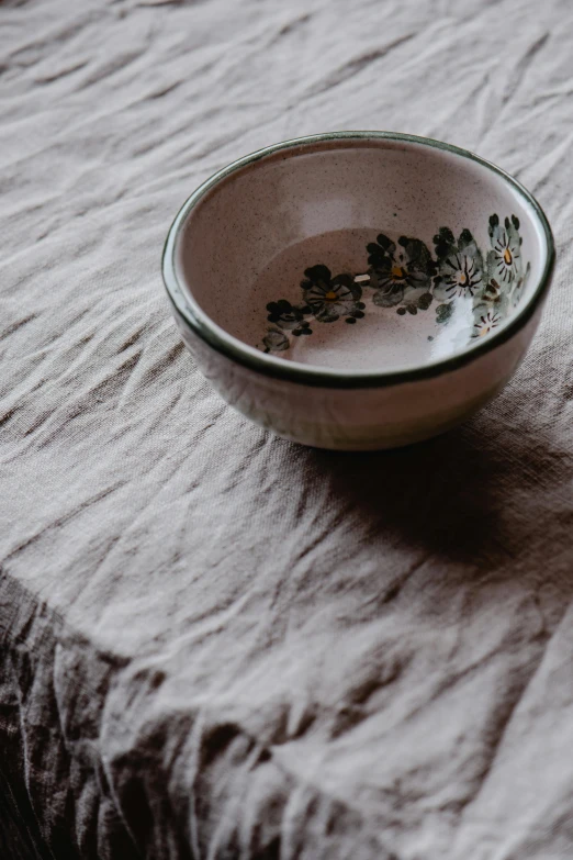 a close up of a bowl on a table, a still life, unsplash, on a sumptuous tablecloth, clover, made of clay, bespoke