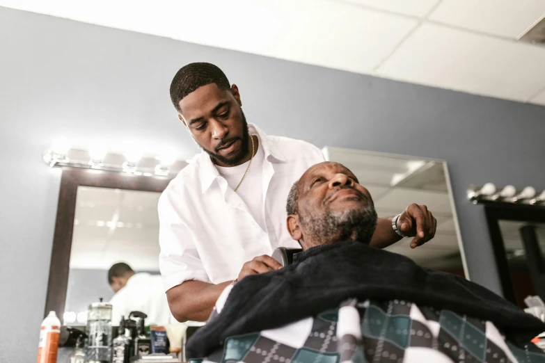 a man getting his hair cut at a barber shop, by Dan Frazier, pexels contest winner, black man, gray beard, thumbnail, brightly lit