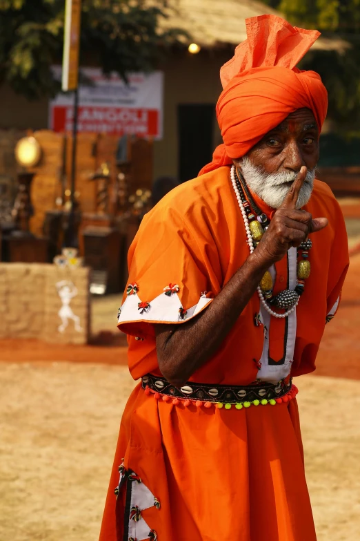 a man in an orange turban smoking a cigarette, pexels contest winner, bengal school of art, dancing character, secretly on a village, at khajuraho, ( ( theatrical ) )