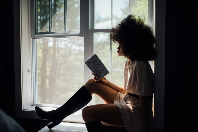 a woman sitting on a window sill reading a book, a portrait, by Carey Morris, pexels contest winner, with afro, kneehigh boots, with backlight, instagram post