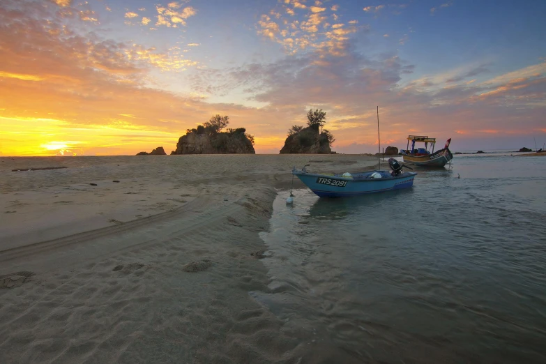 a couple of boats sitting on top of a sandy beach, unsplash contest winner, sumatraism, sunset panorama, fishing, malaysian, multicoloured