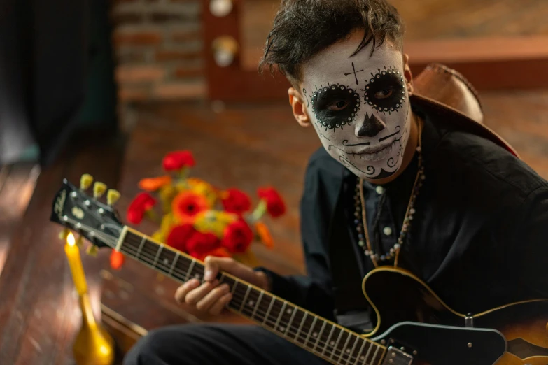 a man sitting on a bench with a guitar, pexels contest winner, vanitas, skull face paint, avatar image, mexican, performing a music video