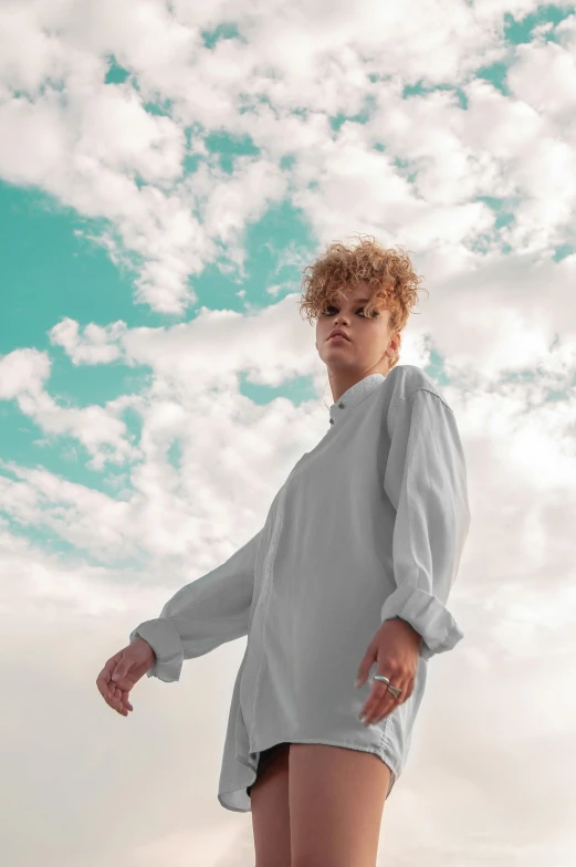 a woman standing on a skateboard in front of a cloudy sky, an album cover, by irakli nadar, trending on pexels, renaissance, red haired teen boy, wearing white pajamas, short curly blonde haired girl, androgynous male