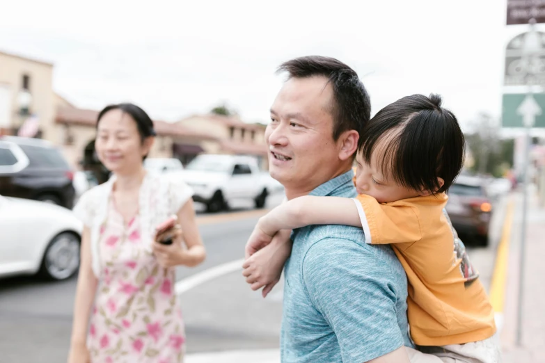 a man carrying a little girl on his shoulders, unsplash, shin hanga, walking through a suburb, avatar image, background image, lachlan bailey