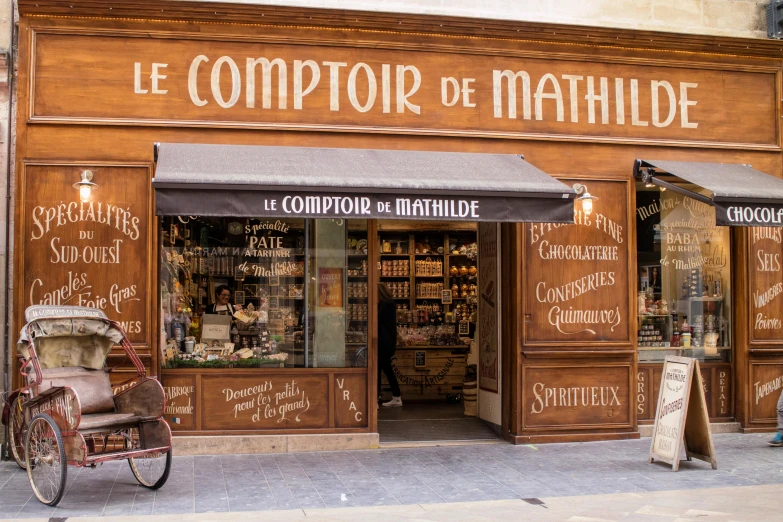 a bicycle parked in front of a store, by Raphaël Collin, pexels contest winner, art nouveau, brown and cream color scheme, eating, mattell, group photo