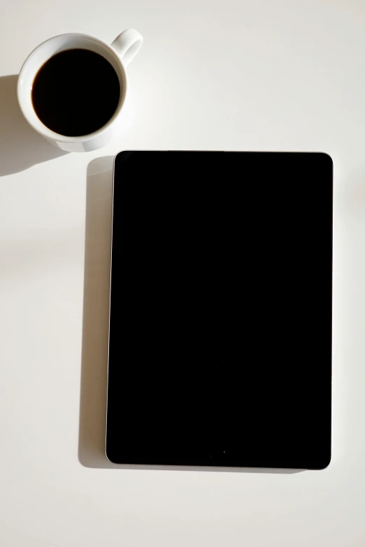 a tablet computer sitting on top of a table next to a cup of coffee, by Carey Morris, minimalism, 8 k -, portrait n - 9, full frame image, - n 9