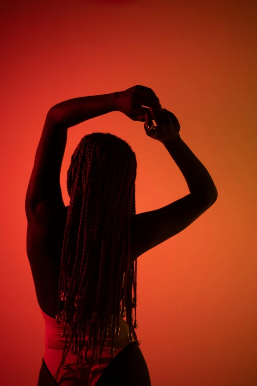 a woman standing in front of a red background, by James Warhola, pexels contest winner, afrofuturism, hands in her hair. side-view, perfect female body silhouette, box braids, isolated on white background