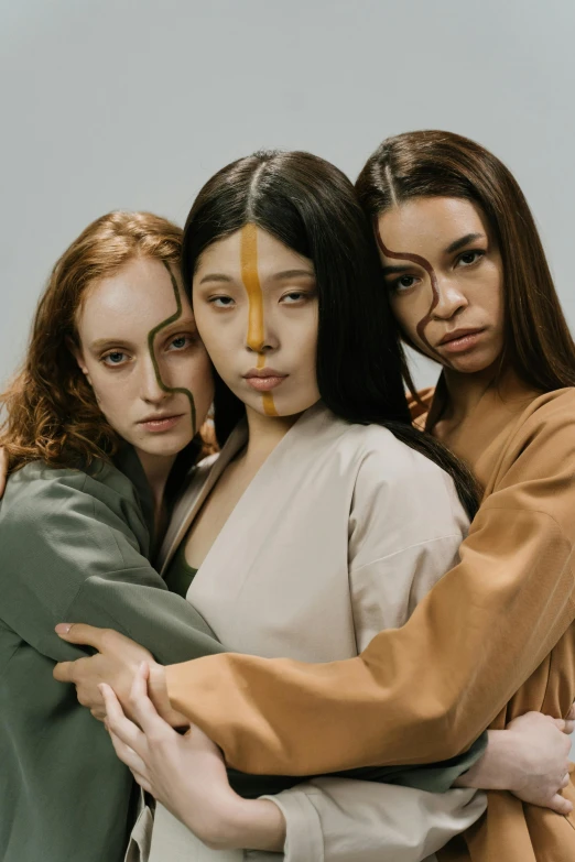 a group of three women standing next to each other, inspired by Zhang Xiaogang, trending on pexels, renaissance, earthtone colors, makeup, neanderthal people, lesbian embrace