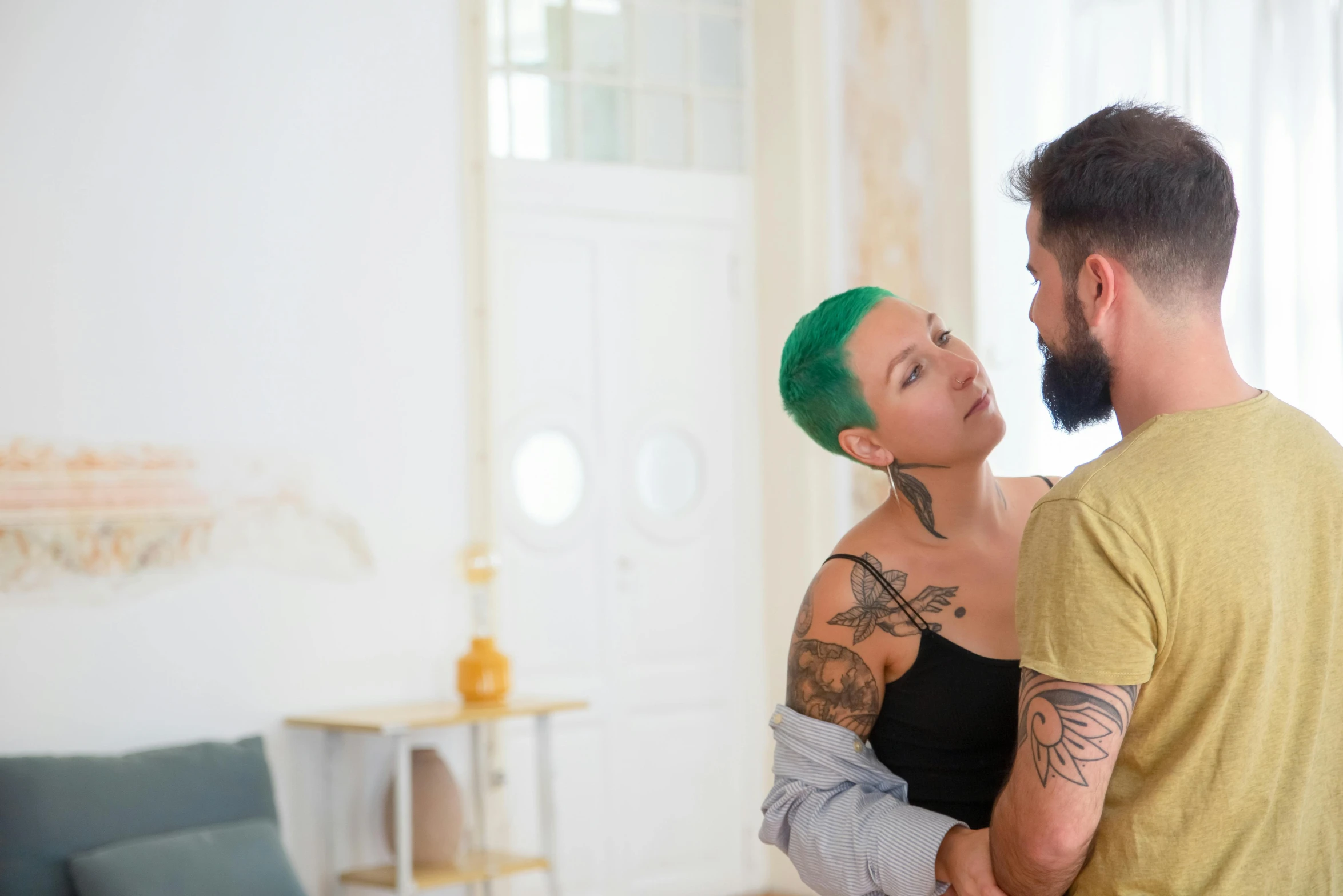 a man standing next to a woman with green hair, a tattoo, pexels contest winner, location in a apartment, embrace, profile image, ( ( theatrical ) )