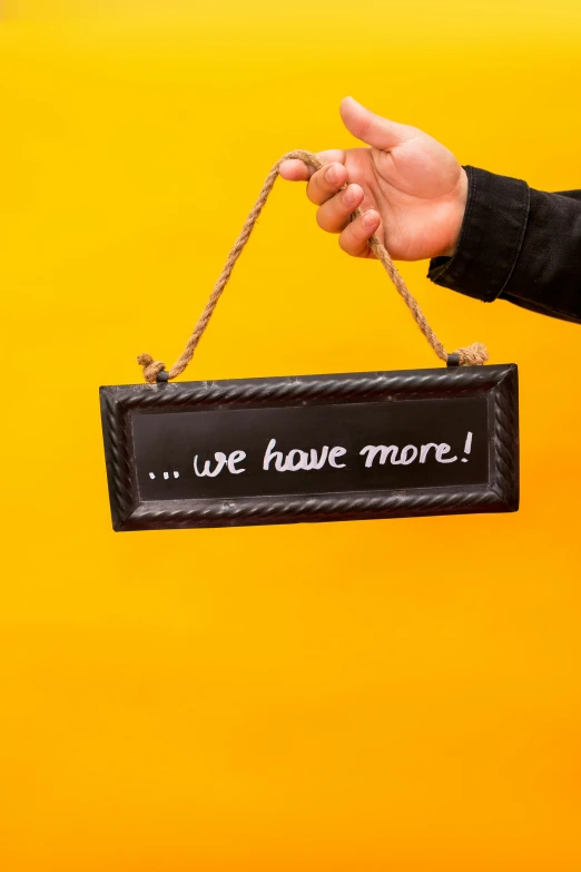 a person holding a sign that says we have more, pexels contest winner, made of smooth black goo, hanging rope, thumbnail, 🚀🌈🤩