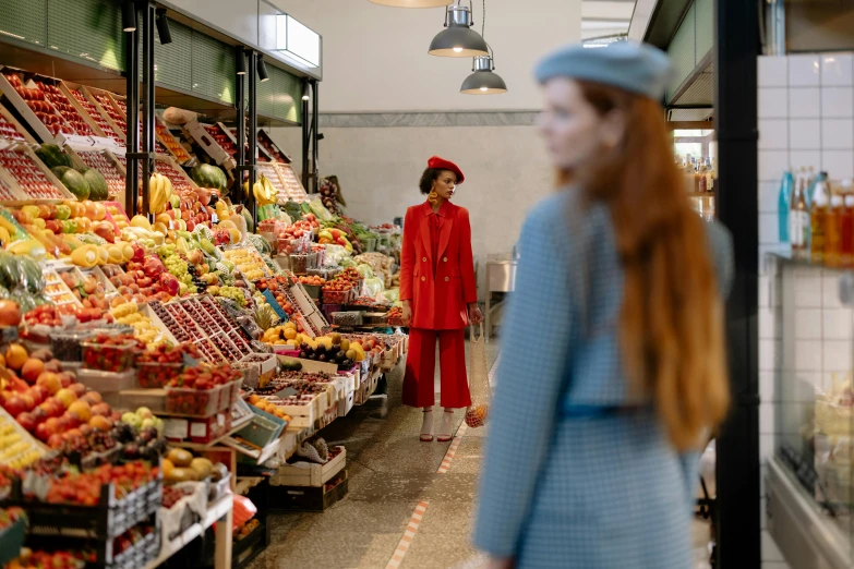 a woman standing in front of a fruit stand, by Anita Malfatti, pexels contest winner, wes anderson and gucci, inside a supermarket, red coat, red hat