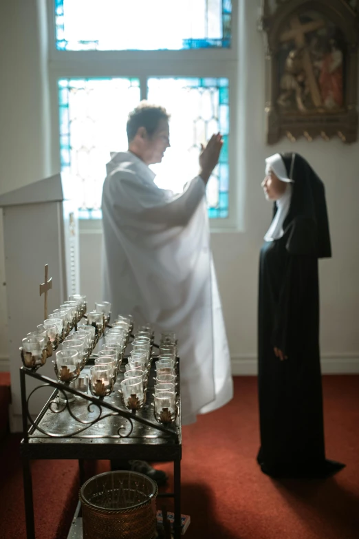 a couple of people that are standing in a room, nun, overturned chalice, biopic, ignant