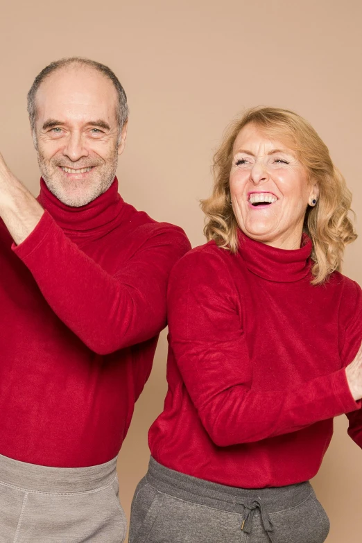 a man and a woman standing next to each other, an album cover, pexels contest winner, antipodeans, wearing a red turtleneck sweater, happy and spirited expression, middle - age, excitement