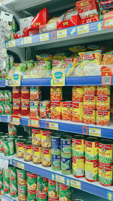 a store filled with lots of different types of food, sitting on a store shelf, scarlet and yellow scheme, barcodes, brand colours are red and blue