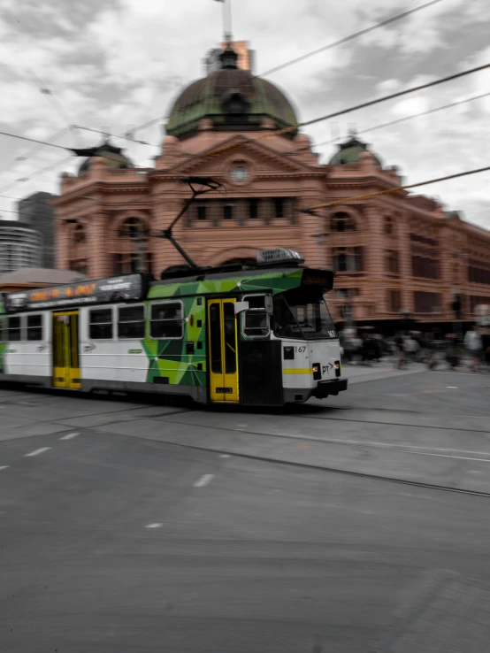 a bus on a city street with a building in the background, inspired by George Pirie, pexels contest winner, trams, southern cross, background image, square