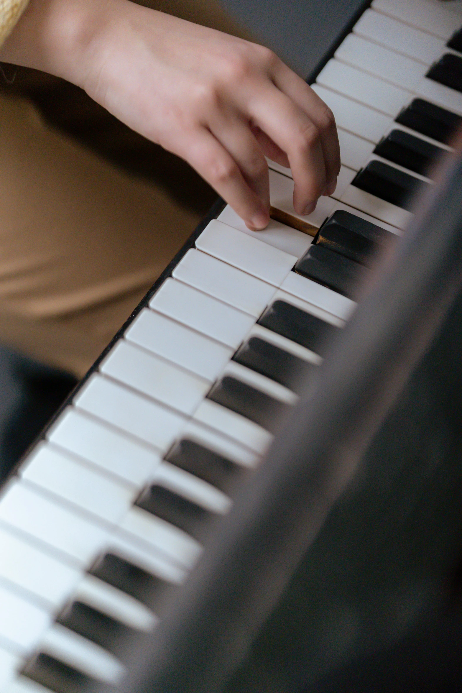 a close up of a person playing a piano, looking towards the camera