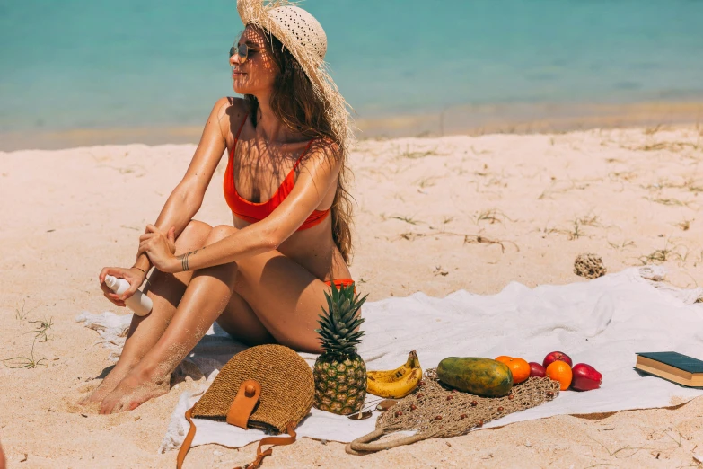 a woman sitting on top of a beach next to a pile of fruit, skincare, tan, upper body image, 🦩🪐🐞👩🏻🦳