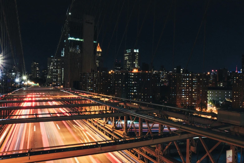 a view of a city at night from the top of a bridge, an album cover, unsplash contest winner, highways, new york city in the year 2100, 2000s photo