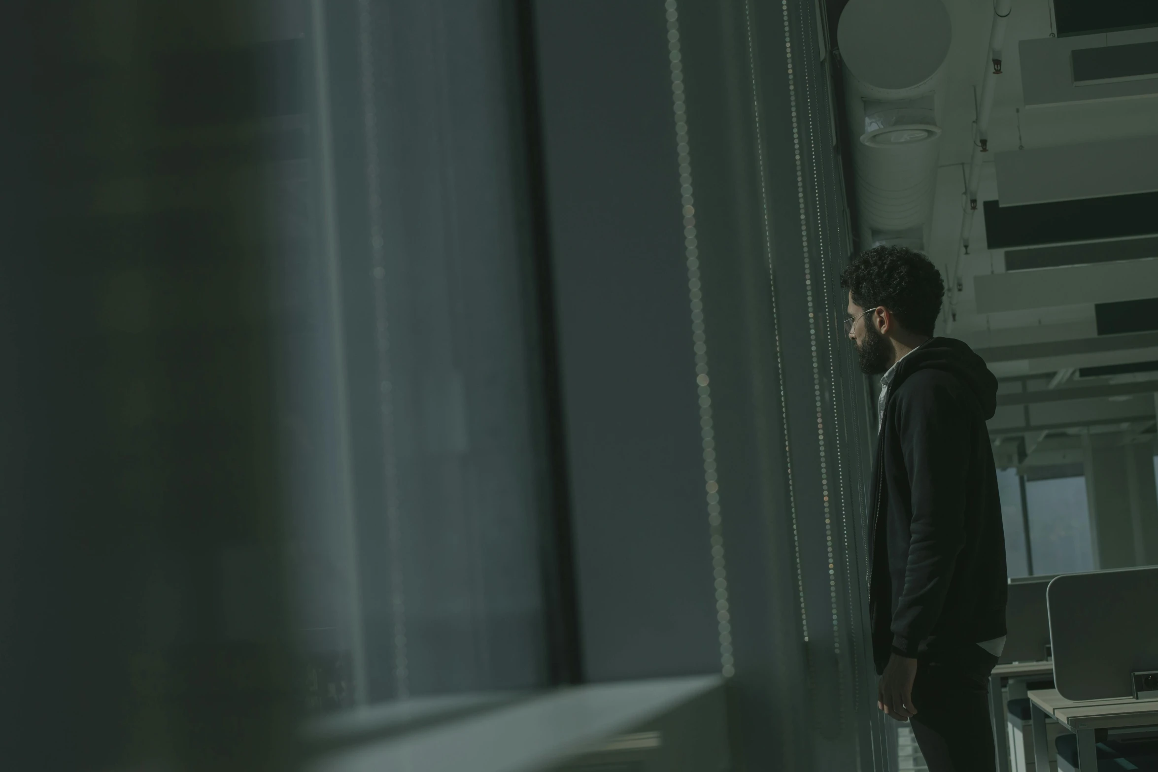 a man standing in an office looking out the window, inspired by Elsa Bleda, pexels contest winner, serial art, standing in a server room, film still from a horror movie, in school hallway, ( ( theatrical ) )