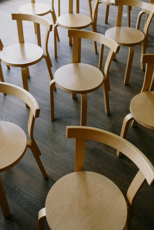 a room filled with lots of wooden chairs, inspired by Constantin Hansen, unsplash, purism, thumbnail, cafe tables, spiraling, oregon