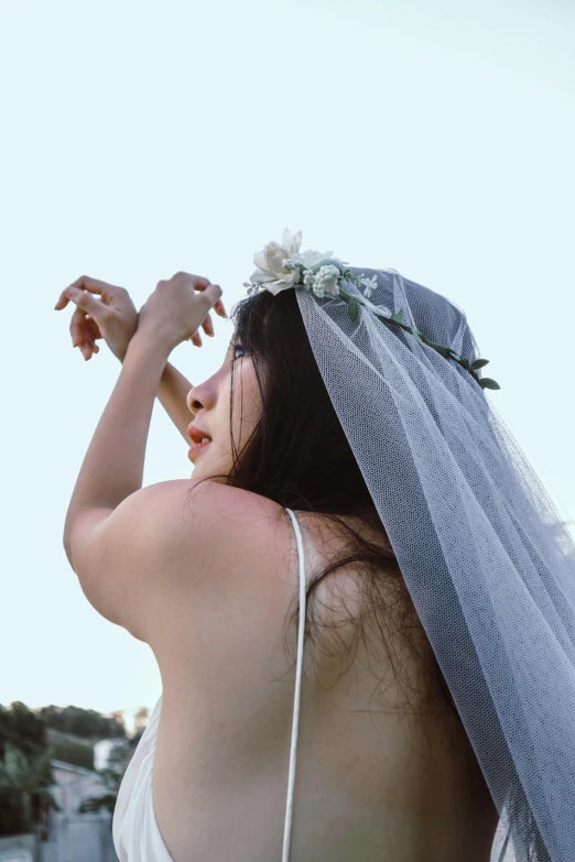 a woman in a wedding dress making a heart with her hands, an album cover, inspired by Ren Hang, unsplash, mesh headdress, jaeyeon nam, looking to the sky, corpse bride style