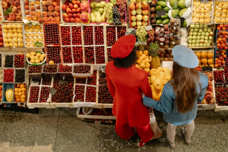 a couple of people standing in front of a fruit stand, by Julia Pishtar, pexels, bird view, wearing a red outfit, inspect in inventory image, woman holding another woman