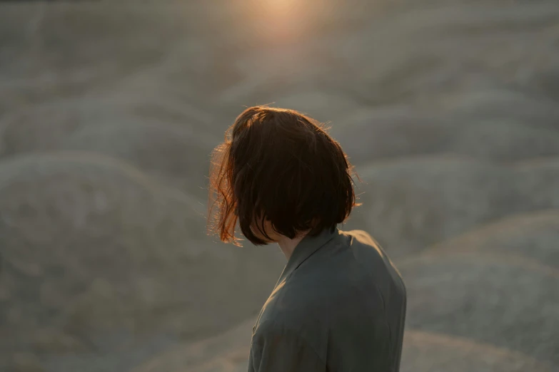 a woman standing in the middle of a desert, unsplash contest winner, australian tonalism, girl with brown hair, evening sunlight, back of head, ignant