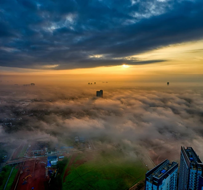 a view of a city from the top of a building, by Sebastian Spreng, pexels contest winner, happening, floating lands in-clouds, during sunrise, drone photo, grass field surrounding the city