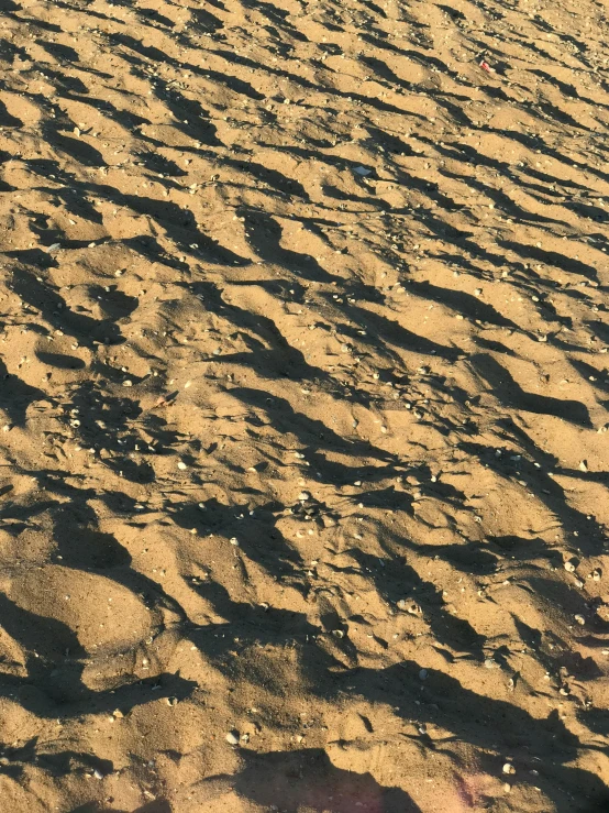 a man flying a kite on top of a sandy beach, an album cover, unsplash, land art, honey ripples, highly detailed # no filter, megascans texture, dappled in evening light