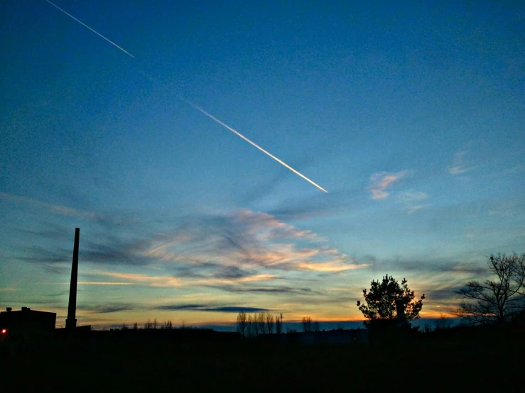 a plane that is flying in the sky, by Joe Stefanelli, pexels contest winner, land art, at twilight, meteor, industrial photography, iphone photo