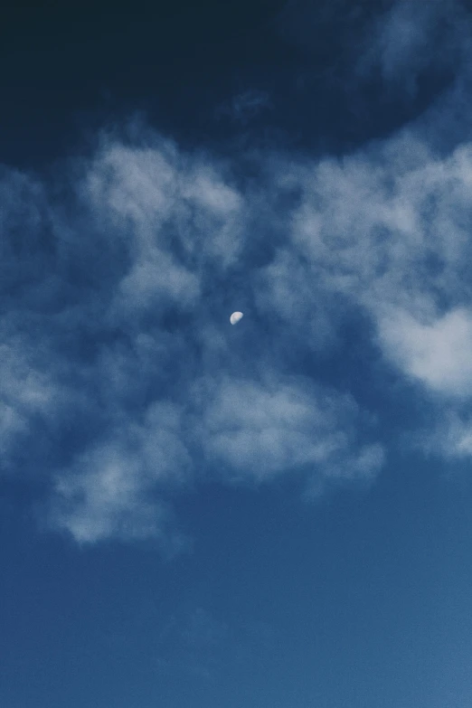 a person is flying a kite high in the sky, a picture, unsplash, minimalism, the moon, face made out of clouds, rinko kawauchi, blue