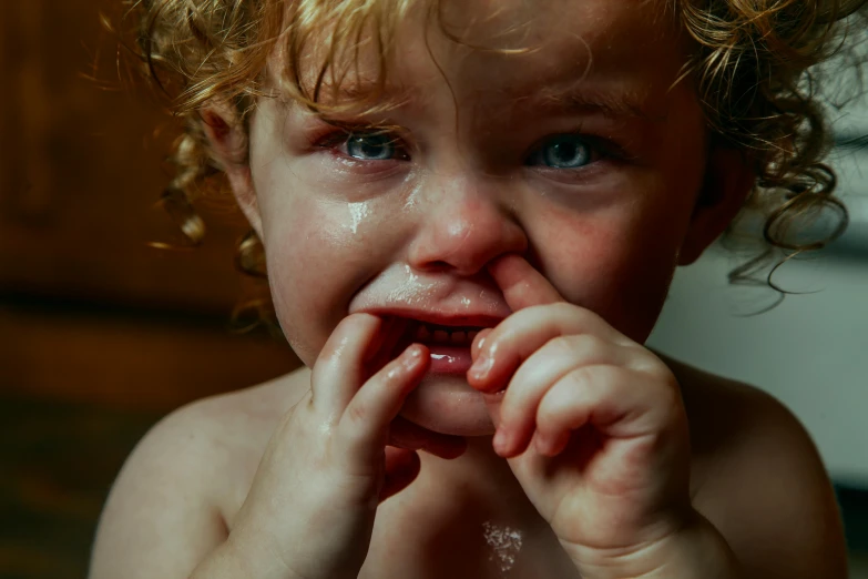 a close up of a child eating a piece of food, by Eglon van der Neer, pexels, hyperrealism, crying tears, thumbnail, ginger hair with freckles, finger