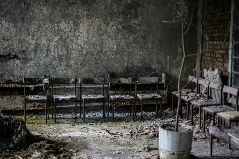 a room that has a bunch of chairs in it, an album cover, by Lucia Peka, unsplash contest winner, arte povera, pripyat, bleak apocalyptic environment, stone pews, in a classroom