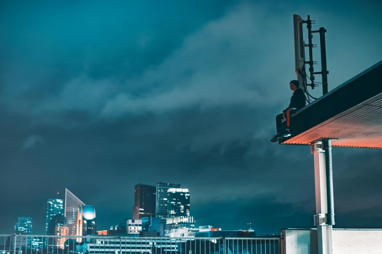 a man sitting on top of a building at night, by Adam Marczyński, pexels contest winner, realism, standing on the mast, manchester, worksafe. cinematic, slightly pixelated
