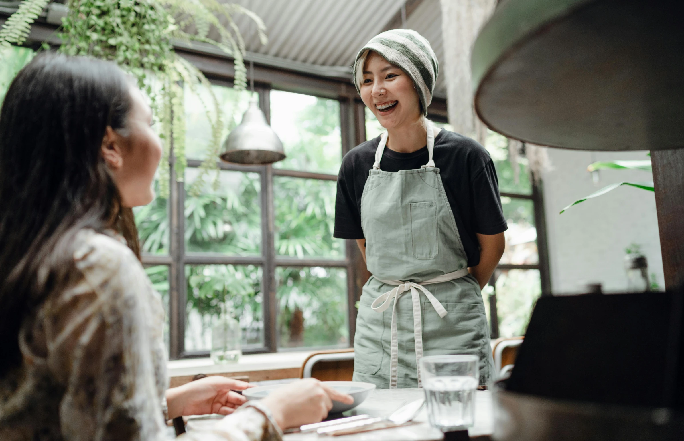 two women sitting at a table in a restaurant, pexels contest winner, apron, green, bjork smiling, chef hat