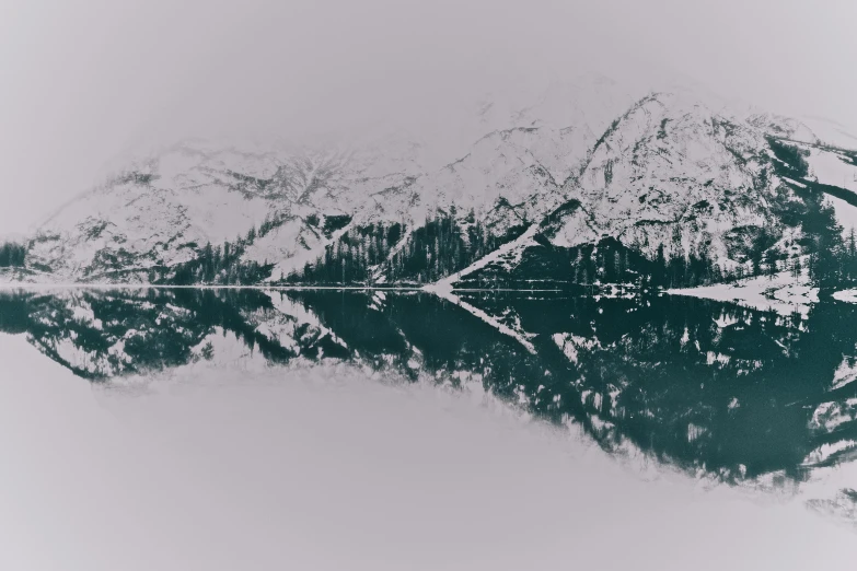 a black and white photo of mountains reflected in a lake, pexels contest winner, minimalism, teal aesthetic, snowy, ilustration, symmetrical image