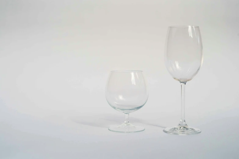 two empty wine glasses sitting next to each other, a still life, unsplash, hyperrealism, white backdrop, various sizes, full product shot, medium angle