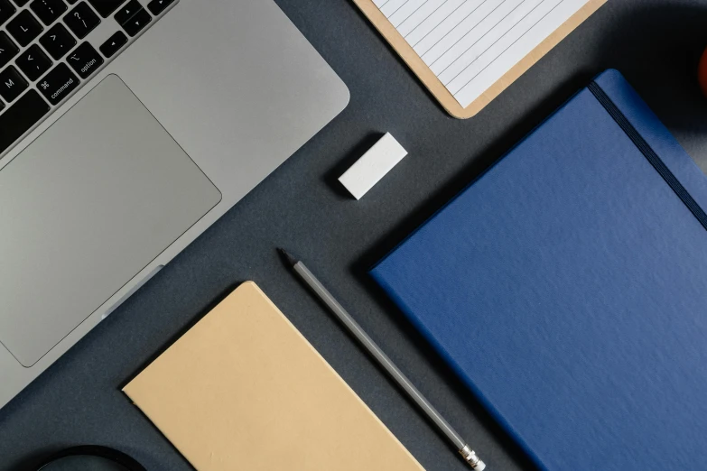 an open laptop computer sitting on top of a desk, trending on unsplash, blue gold and black, staples, square lines, papers