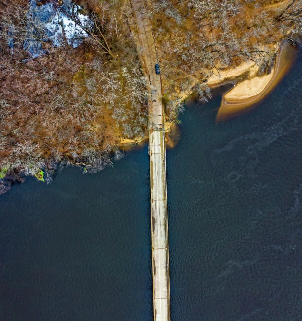 an aerial view of a bridge over a body of water, by Sebastian Spreng, pexels contest winner, cahaba river alabama, winter lake setting, boardwalk, brown