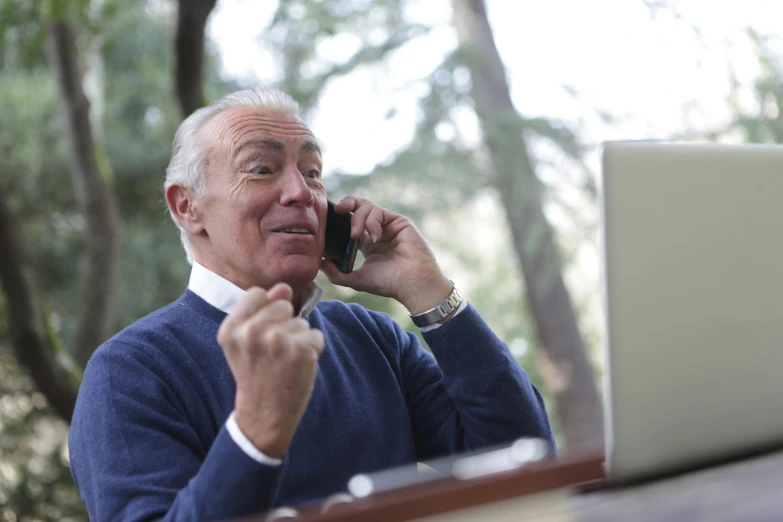 a man sitting in front of a laptop talking on a cell phone, hide the pain harold, excited, 15081959 21121991 01012000 4k, nature outside