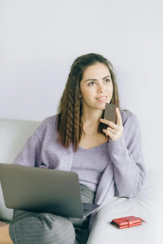 a woman sitting on a couch with a laptop and a cell phone, chocolate, slightly minimal, promo image, talking