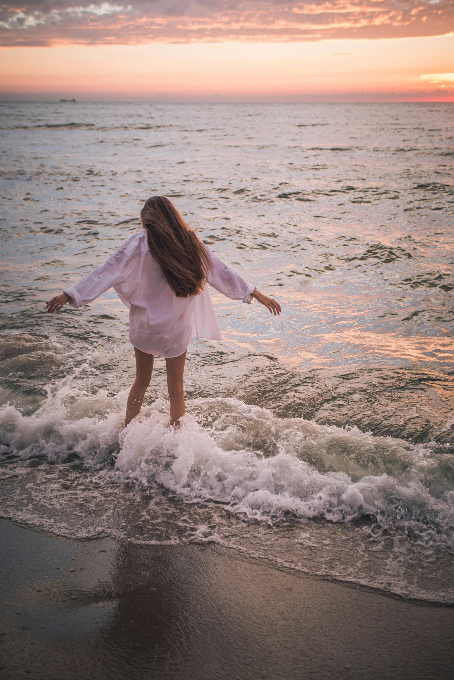 a woman standing on top of a beach next to the ocean, inspired by Elsa Bleda, unsplash contest winner, renaissance, wavy hair spread out, floating in water, at gentle dawn pink light, teenage girl