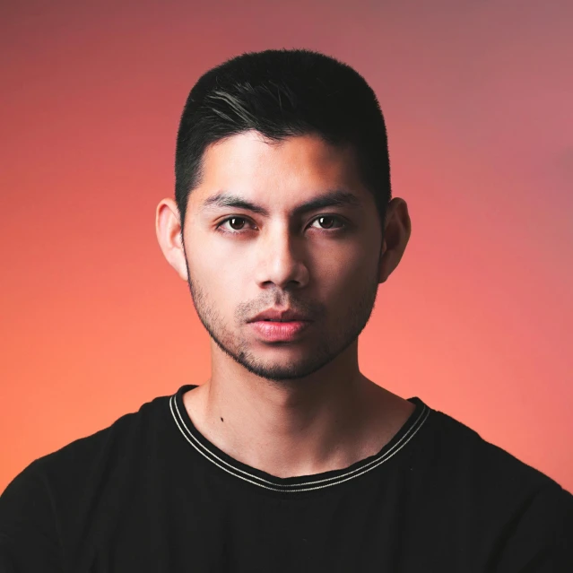 a man in a black shirt posing for a picture, an album cover, inspired by Tadashi Nakayama, pexels contest winner, realism, color studio portrait, south east asian with round face, boyish face, dj