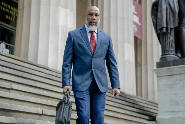 a man in a suit walking down the steps of a building, inspired by William H. Mosby, renaissance, documentary still, defense attorney, a bald, schools