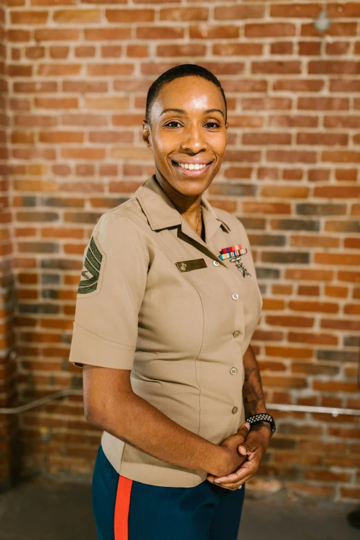 a woman in uniform standing in front of a brick wall, ashteroth, portrait of maci holloway, on clear background, marine