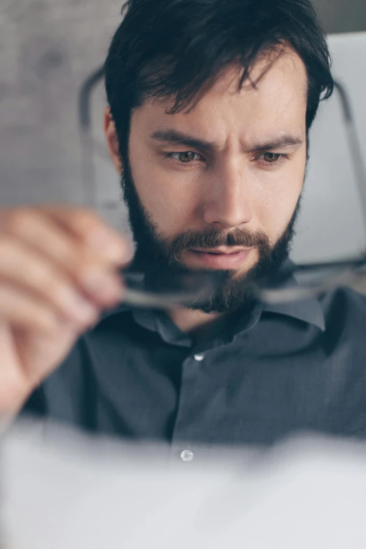 a man holding a pair of scissors in front of his face, pexels contest winner, precisionism, looking at monitor, beard stubble, engineer, square masculine facial features